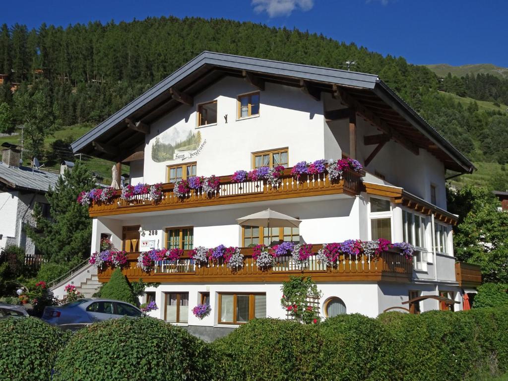 a white building with flowers on the balconies at Apart Pension Bergfrieden in Nauders
