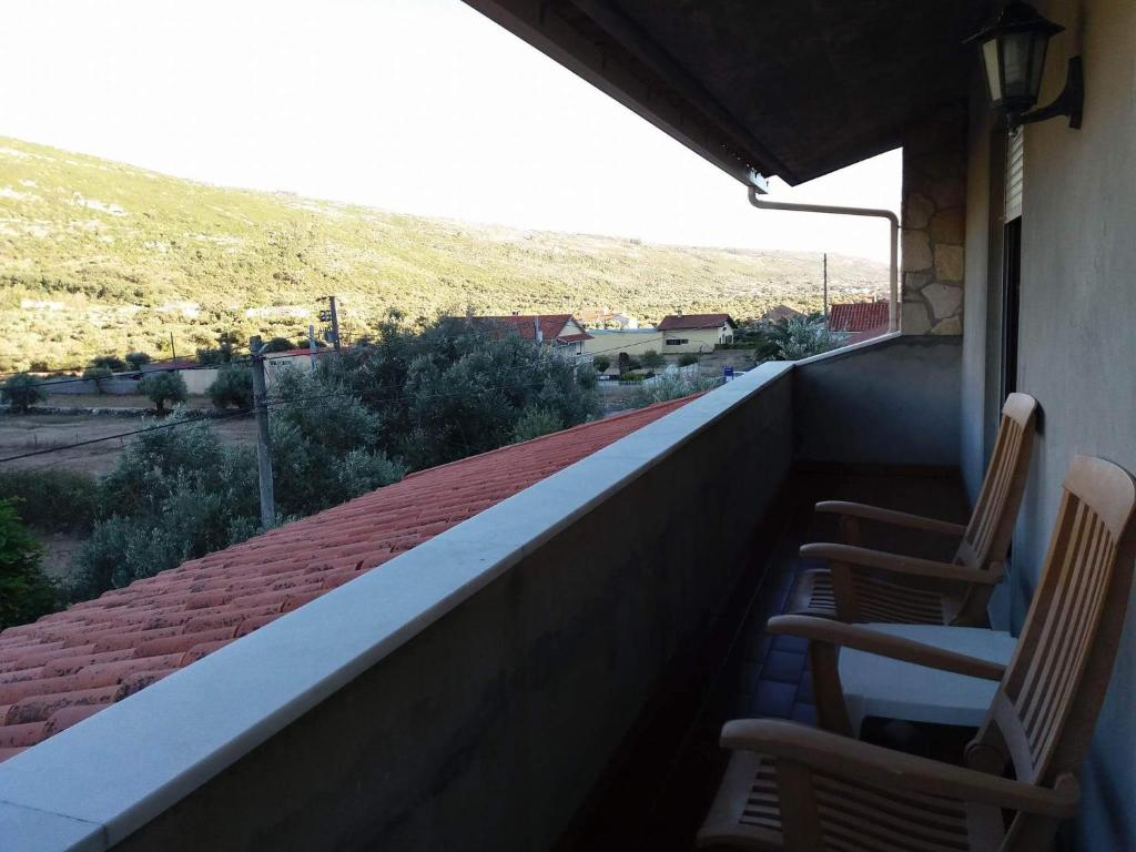 duas cadeiras numa varanda com vista para uma montanha em A casa da serra - alojamento local em Casal Velho