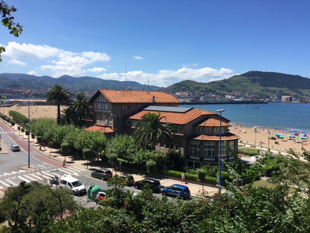 a view of a beach and a building with cars parked at Hotel Igeretxe in Getxo