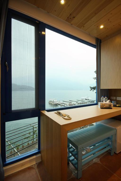 a kitchen with a desk and large windows at Sun Fog Hotel in Yuchi