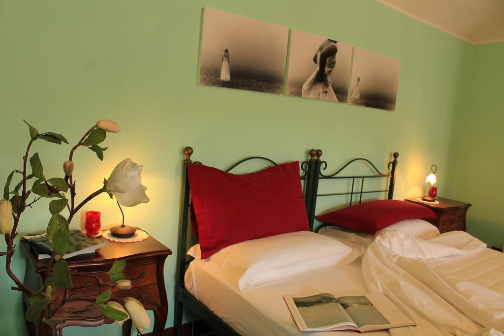 B&B Le Lune في Roppolo: غرفة نوم بسرير وطاولة مع نبات