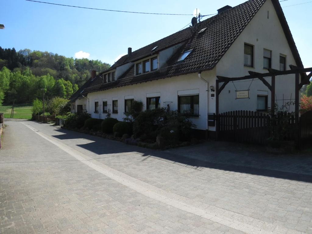 a white house with a black roof and a driveway at Fewo Scherb in Trulben