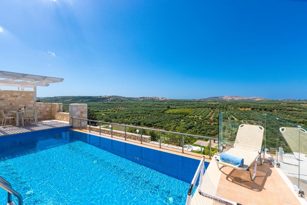a villa with a swimming pool with a view at Kampos Villas, pure elegance, By ThinkVilla in Achlades