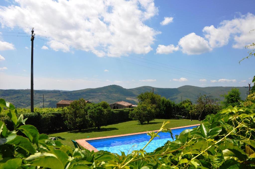a swimming pool in a yard with mountains in the background at Fattoria Castelvecchi in Radda in Chianti