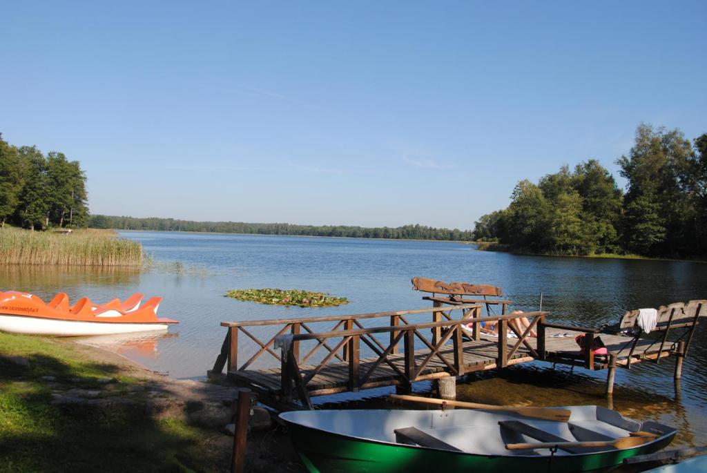 Un muelle en un lago con dos barcos. en Sodyba Ciciriai, en Vėdariai