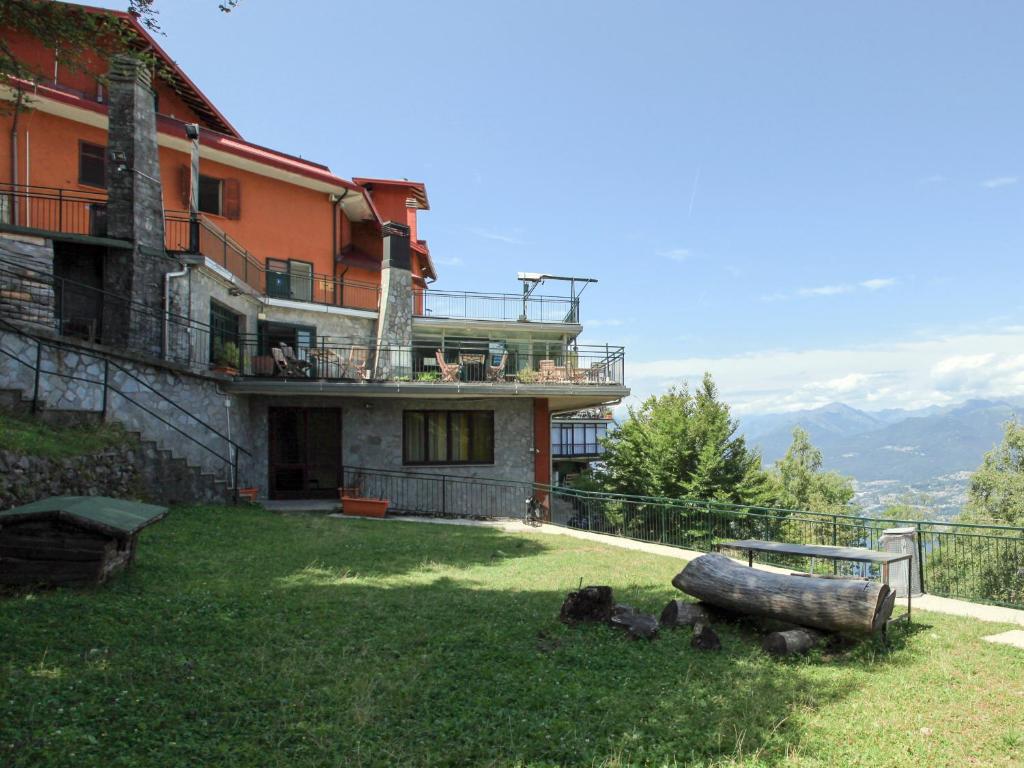 una casa en una colina con un tronco en el patio en Hotel Funivia, en Laveno-Mombello