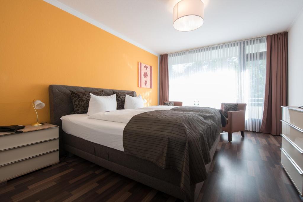 Un dormitorio con una cama grande y una ventana en Hotel Joh en Bad Salzuflen