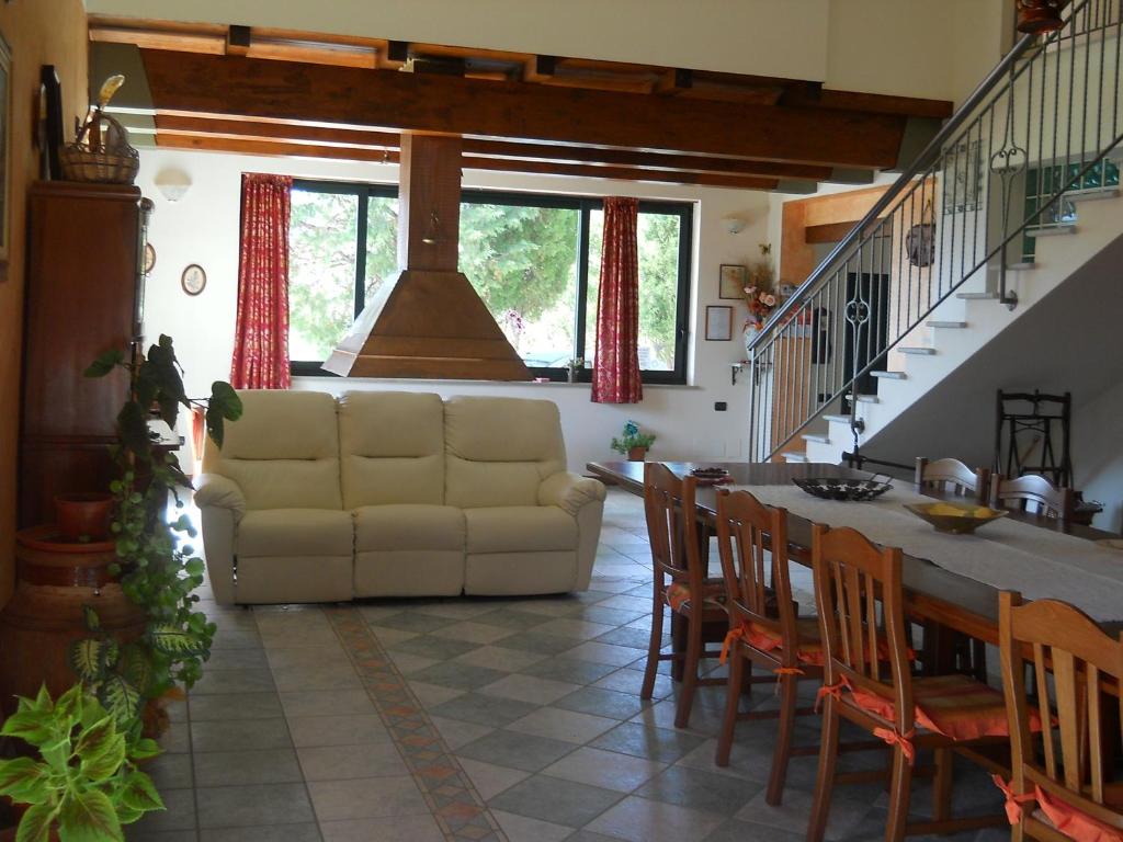 a living room with a couch and a table and chairs at B&B Sciarammola in Patti