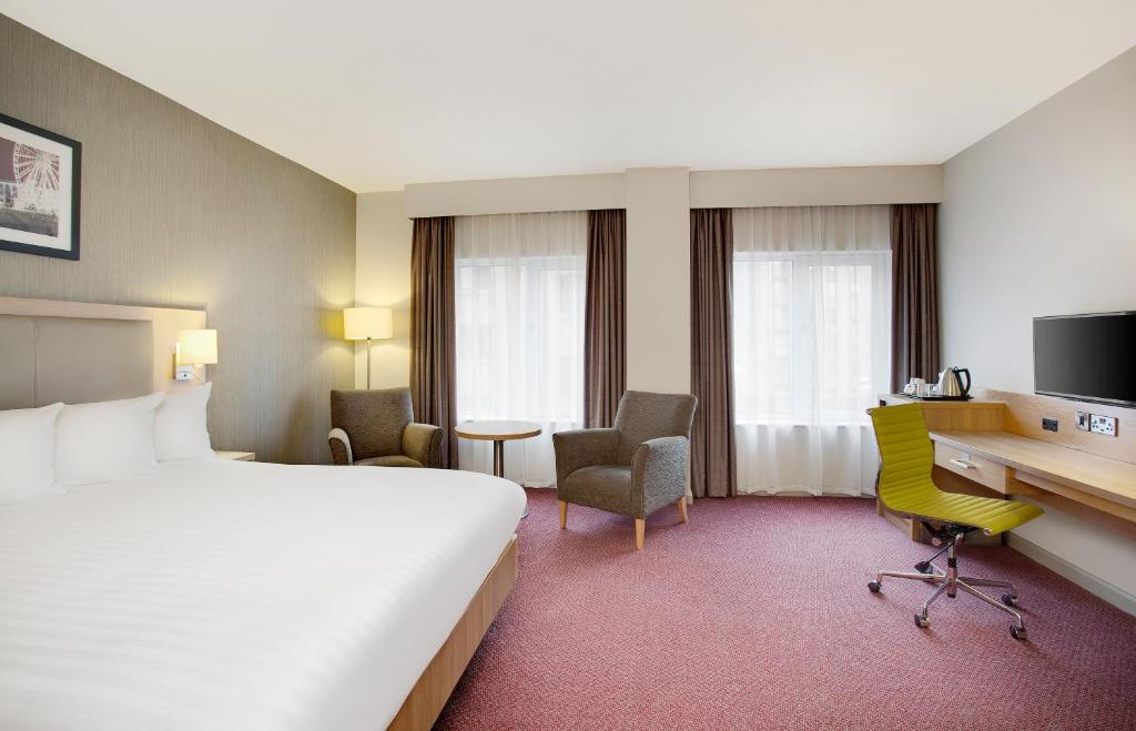a hotel room with a large bed and a desk at Leonardo Hotel Manchester Central in Manchester