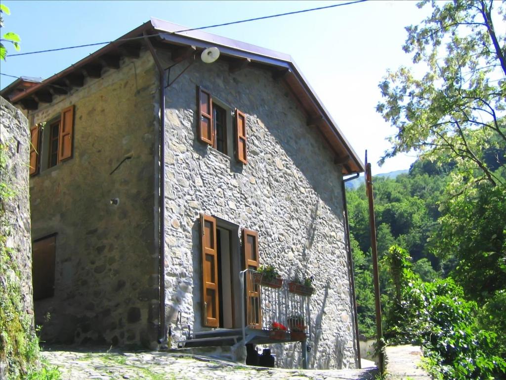 PescagliaにあるCasa Martaの褐色のシャッター窓のある石造りの家