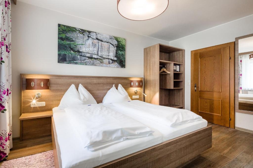 1 dormitorio con 1 cama grande con sábanas blancas en Gasthof Gierlinger, en Obermühl