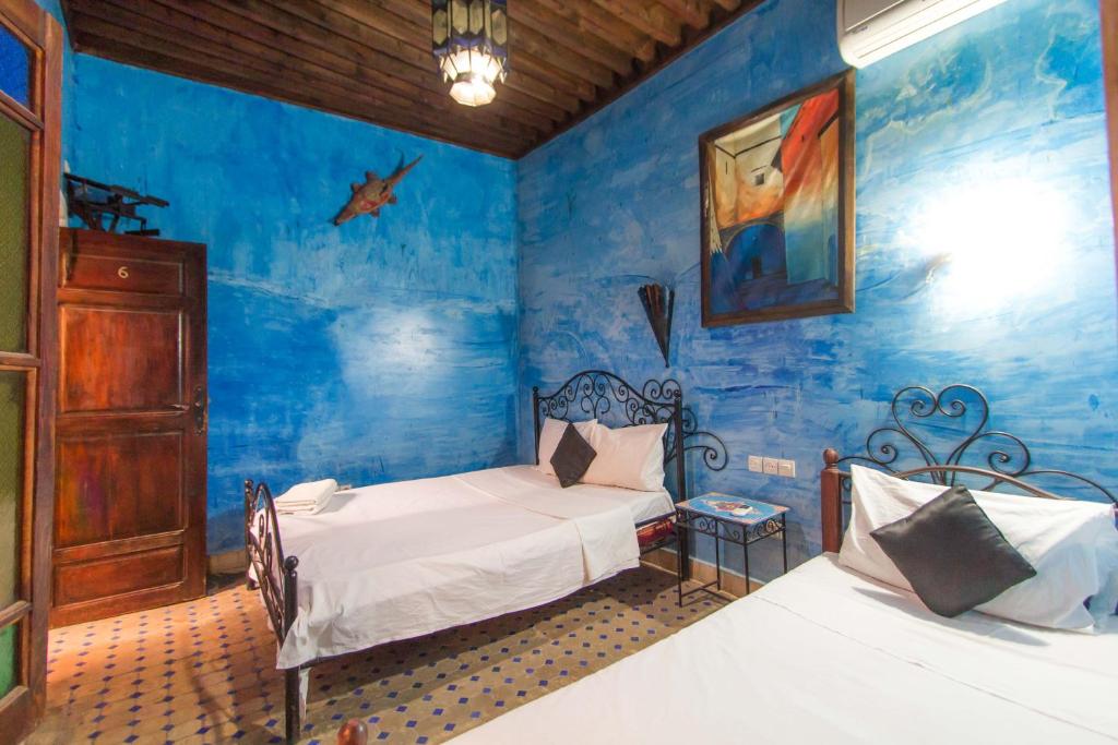1 dormitorio con 2 camas y pared azul en Riad Anass Al Ouali, en Fez