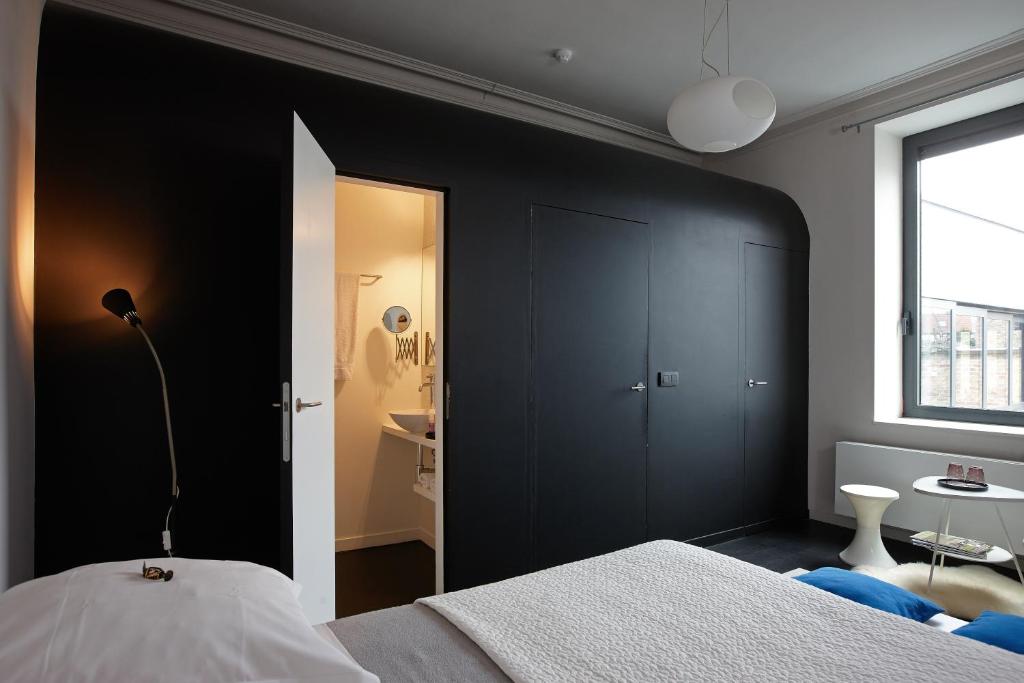 een slaapkamer met een muur met zwarte accenten en een bed bij Bruges by Night in Brugge