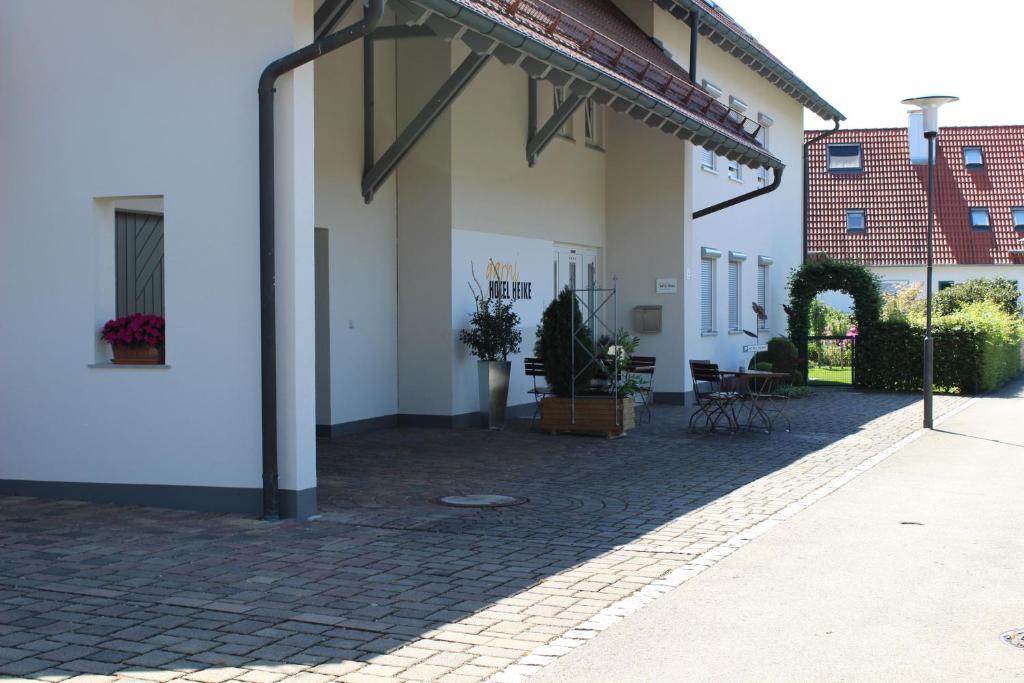 a white building with a patio with plants on it at Hotel Heike garni in Günzburg