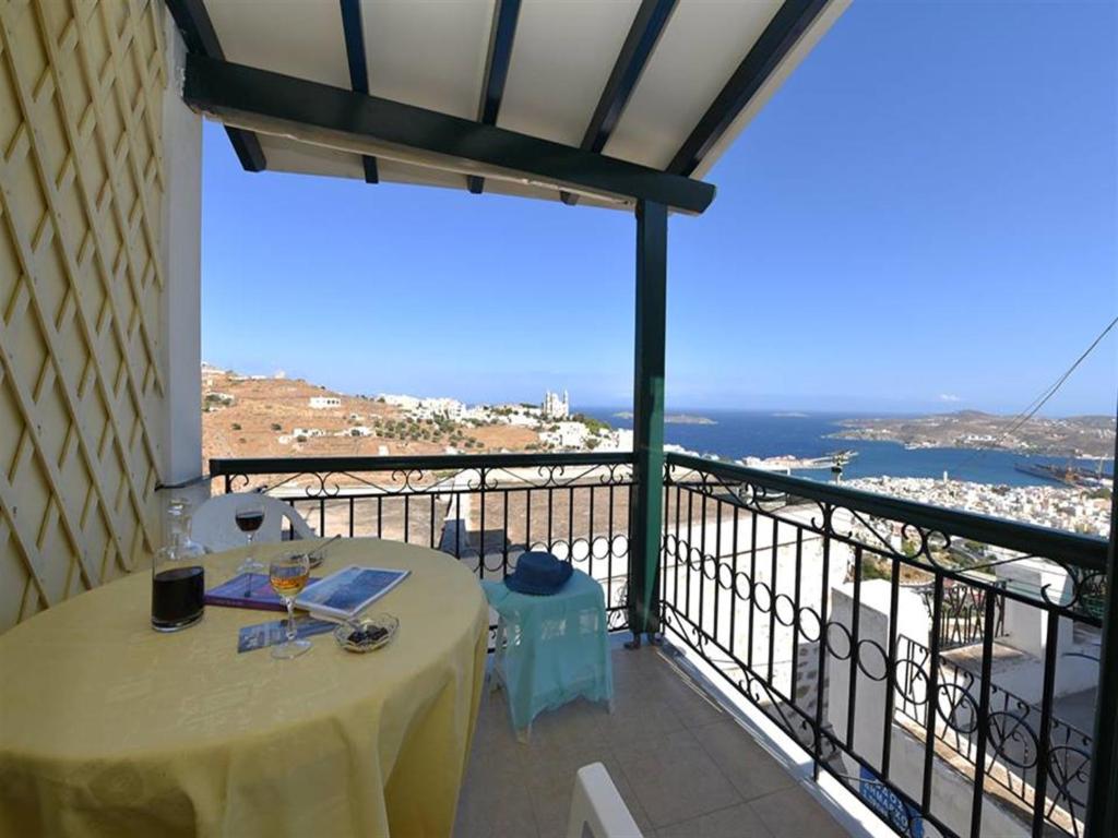 una mesa en un balcón con vistas al océano en Akadia Syros, en Ermoupoli