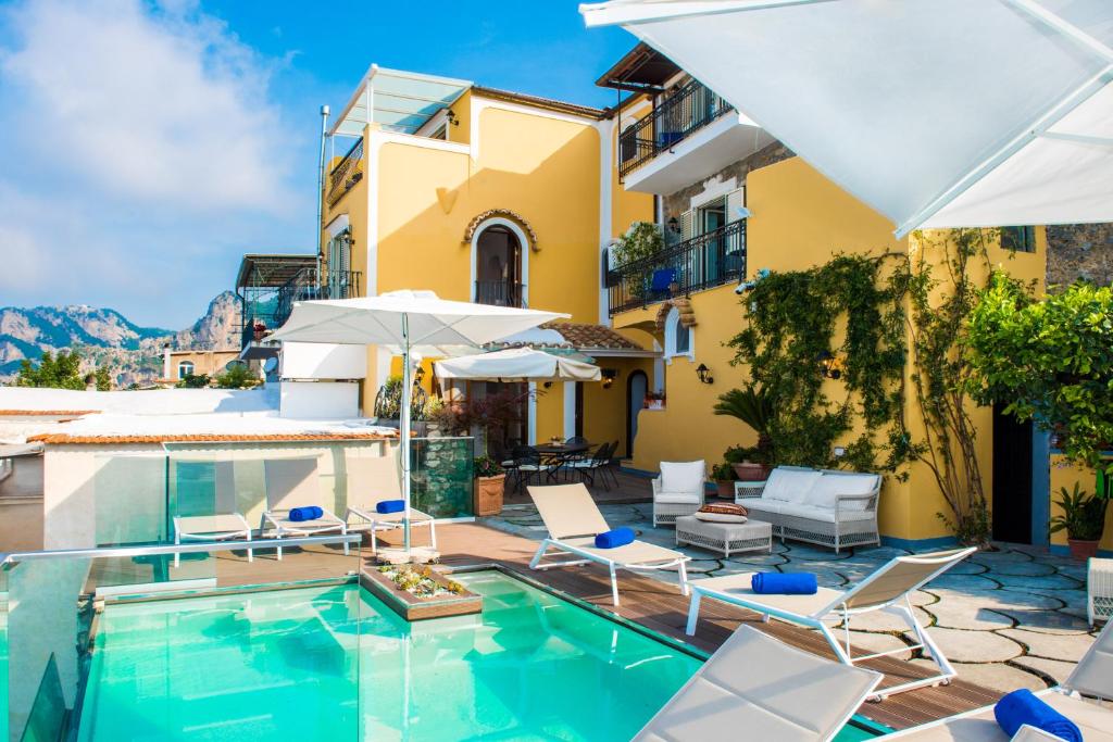 a villa with a swimming pool and patio furniture at Villa Degli Dei Luxury House in Positano