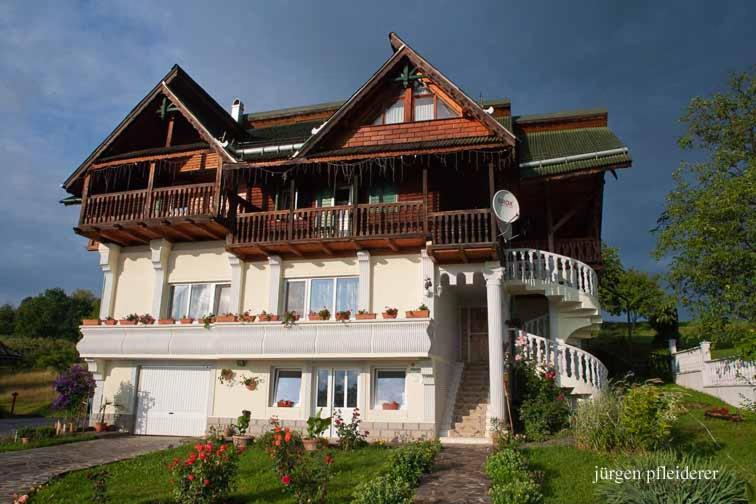 a large house with a gambrel roof at Pensiunea Amethyst in Şurdeşti