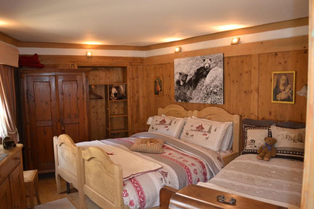 een slaapkamer met 2 bedden en een tafel. bij B&B La Tana dell'Orso - Die Bärenhöhle in Castello di Fiemme