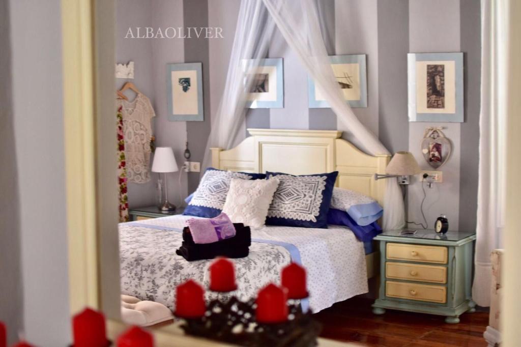 a doll house bedroom with a bed and a mirror at Alojamiento San Juan Bautista in Cazorla