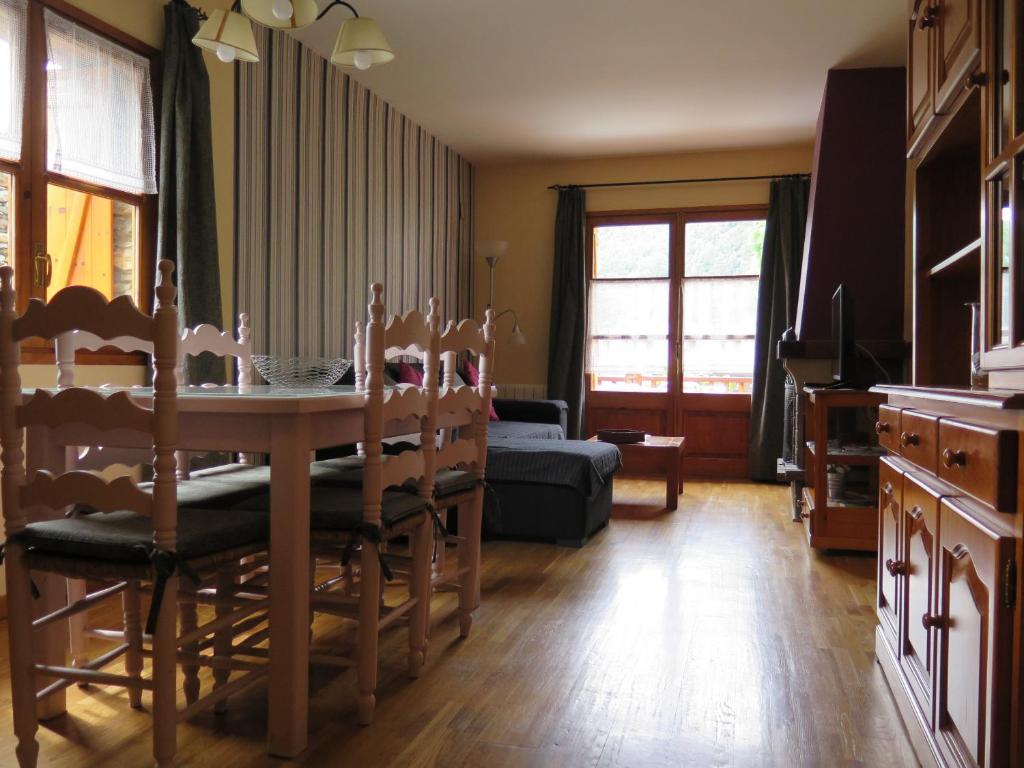 uma sala de estar com uma mesa e cadeiras e um sofá em Apartaments El Ribal em Valencia de Aneu