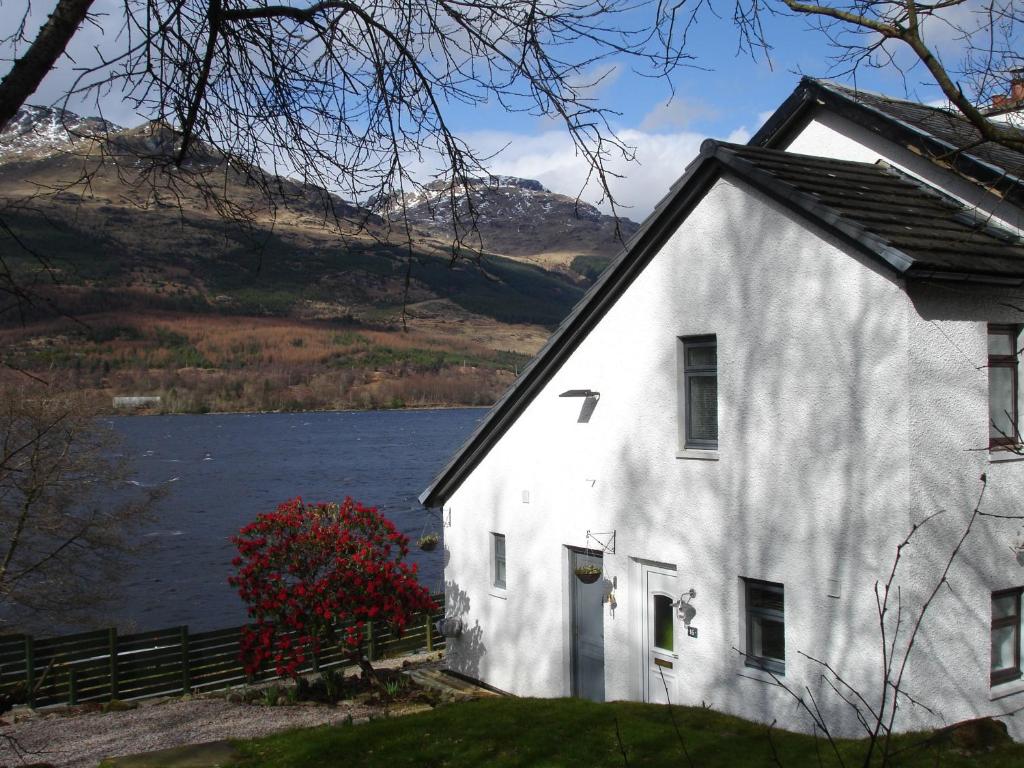 a white house with a lake in the background at 16 Admiralty in Arrochar