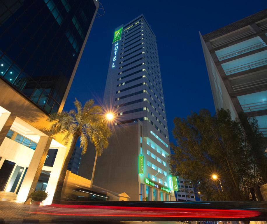 a tall building in a city at night at ibis Styles Manama Diplomatic Area in Manama