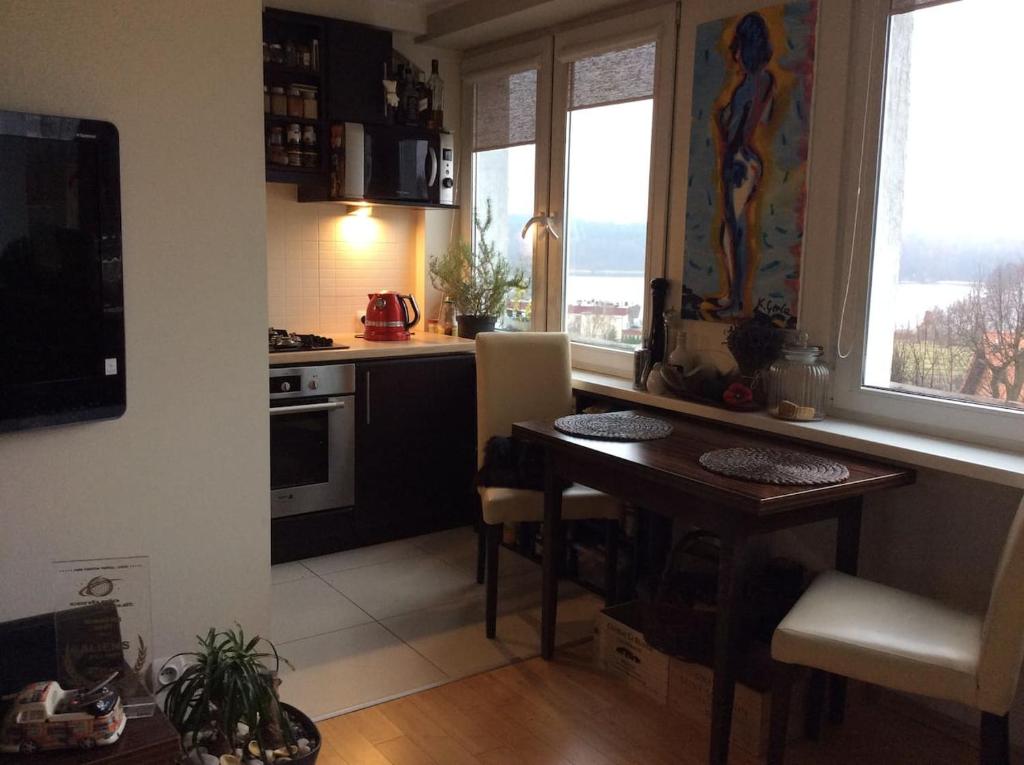 オルシュティンにあるWidokowy Apartament nad Jezioremのテーブル付きのキッチン、窓2つ付きのキッチンが備わります。