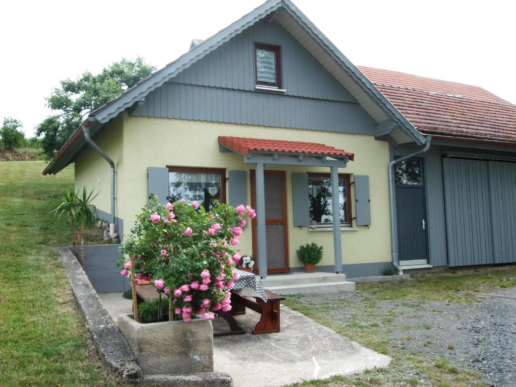 une petite maison avec un banc devant elle dans l'établissement Ferienwohnung Bockelt, à Stadtlauringen