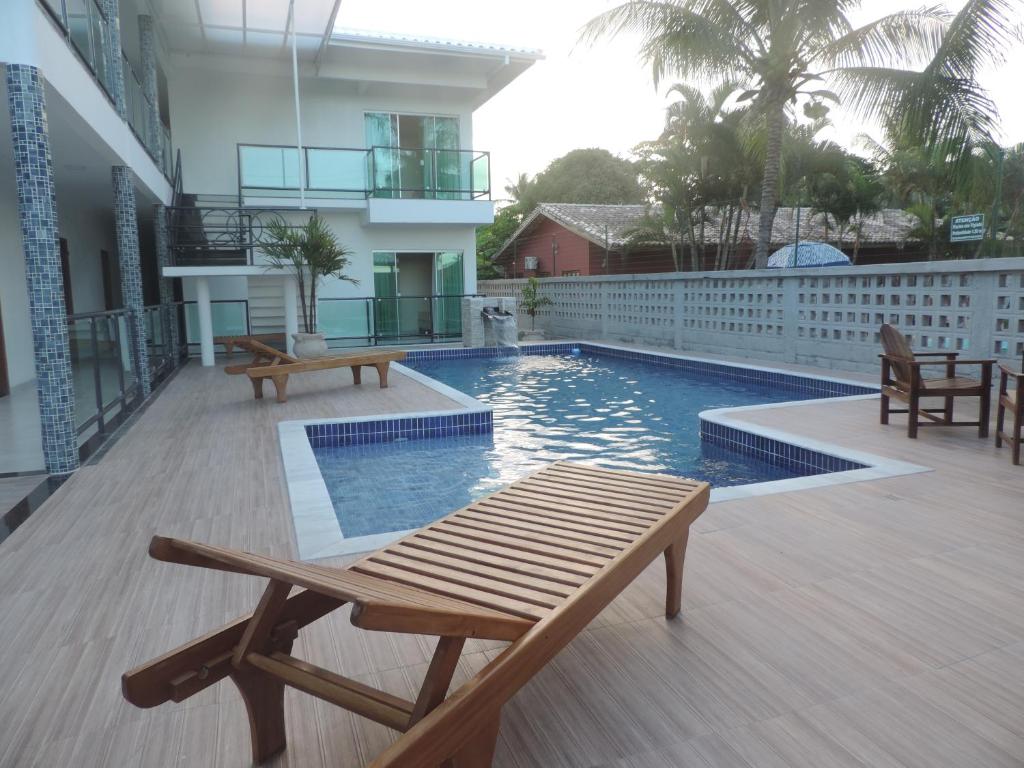 a swimming pool with a bench on a balcony at Areia do Atlantico Hotel in Porto Seguro