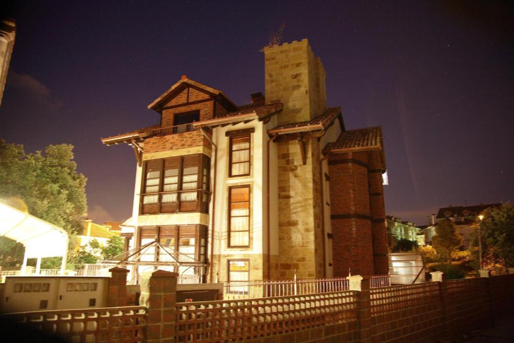 um edifício antigo com uma torre no topo de uma cerca em Posada-Spa Privilegio de Vara em Noja