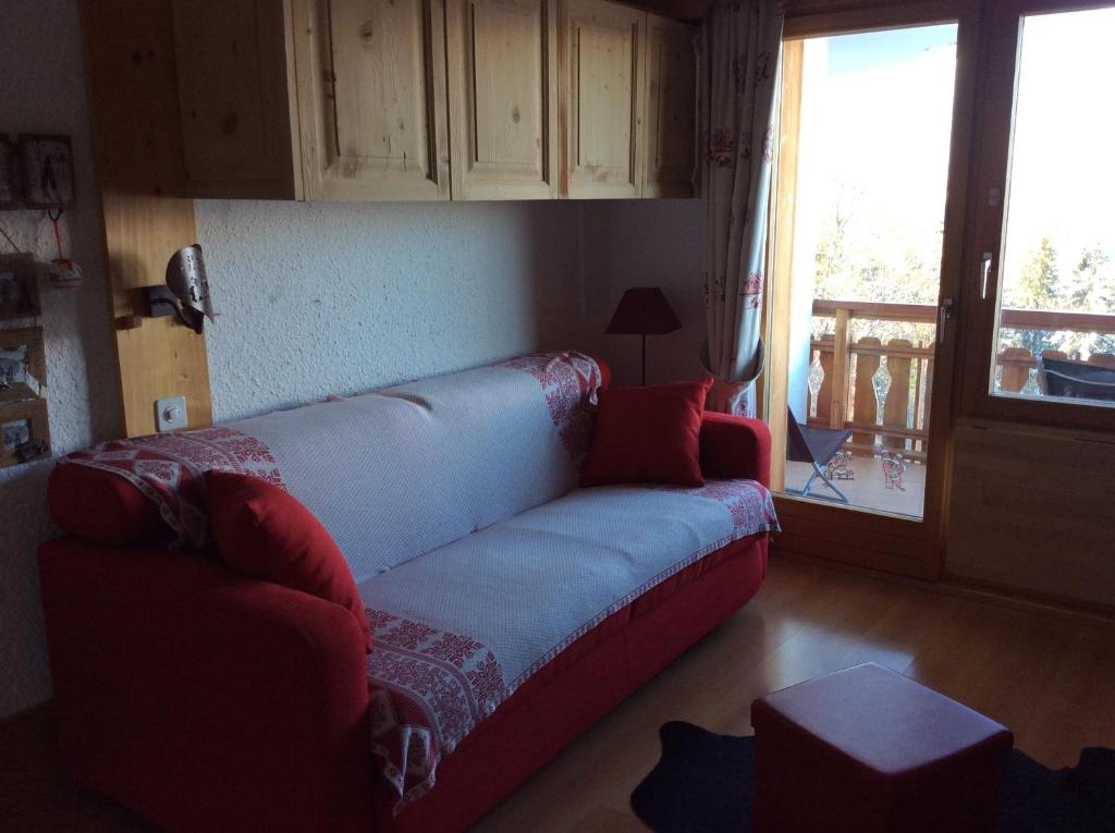 a living room with a couch and a balcony at Le Bristol - Villars Bristol Apartments in Villars-sur-Ollon