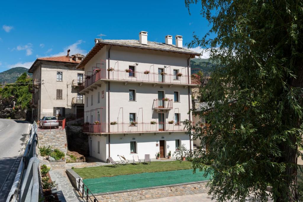 duży biały dom na wzgórzu w obiekcie La Pietra Felice w mieście Introd