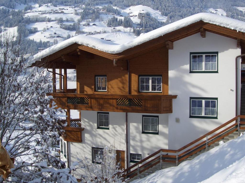 une maison avec un toit recouvert de neige dans l'établissement Ferienwohnung Sonnentraum, à Hainzenberg