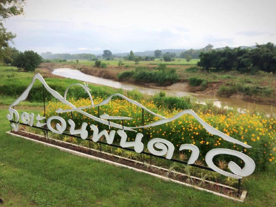 a sign in the middle of a field of flowers at Phutawan Pundao in Mae Taeng