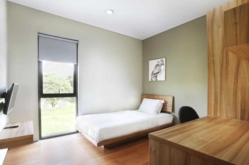 1 dormitorio con cama y ventana en M Pavilion - Lippo Karawaci en Tangerang