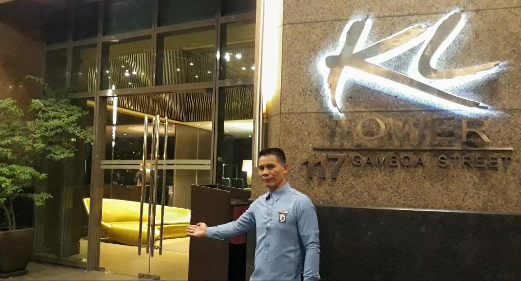 KL Executive Greenbelt (KLX) في مانيلا: رجل واقف امام مبنى