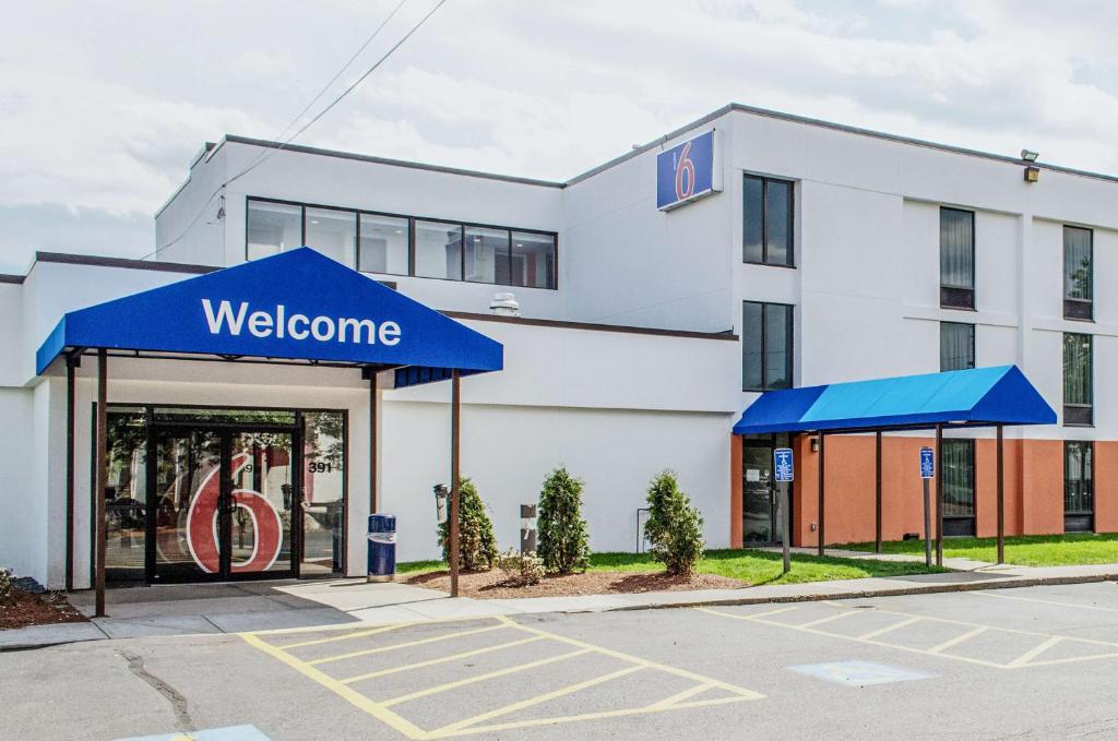 un panneau de bienvenue devant un bâtiment dans l'établissement Motel 6-Brockton, MA, à Brockton