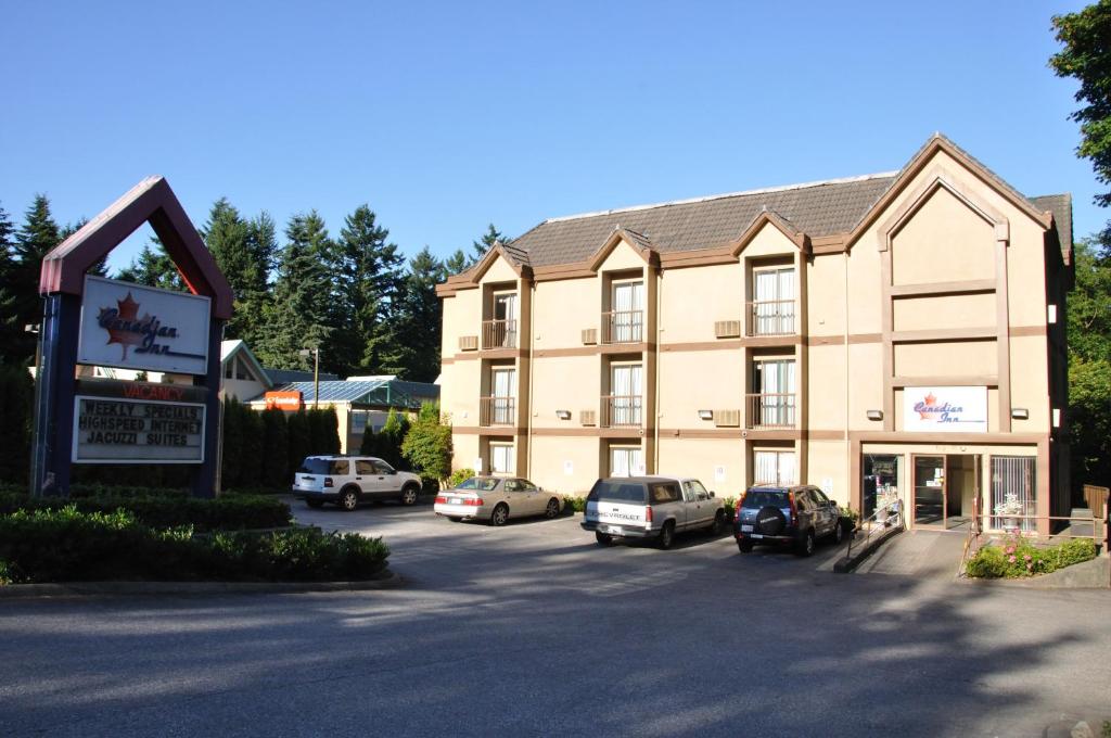 a large building with cars parked in a parking lot at Canadian Inn in Surrey
