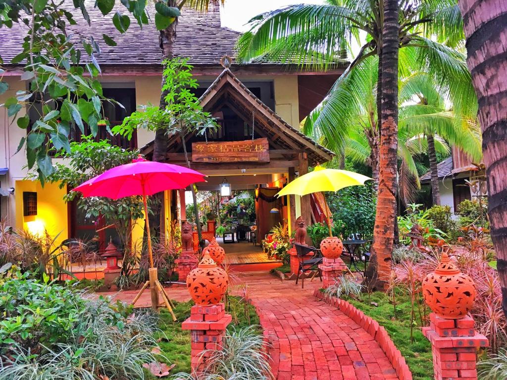 a walkway with umbrellas in front of a house at Xishuangbanna Elephant Home Guesthouse in Jinghong