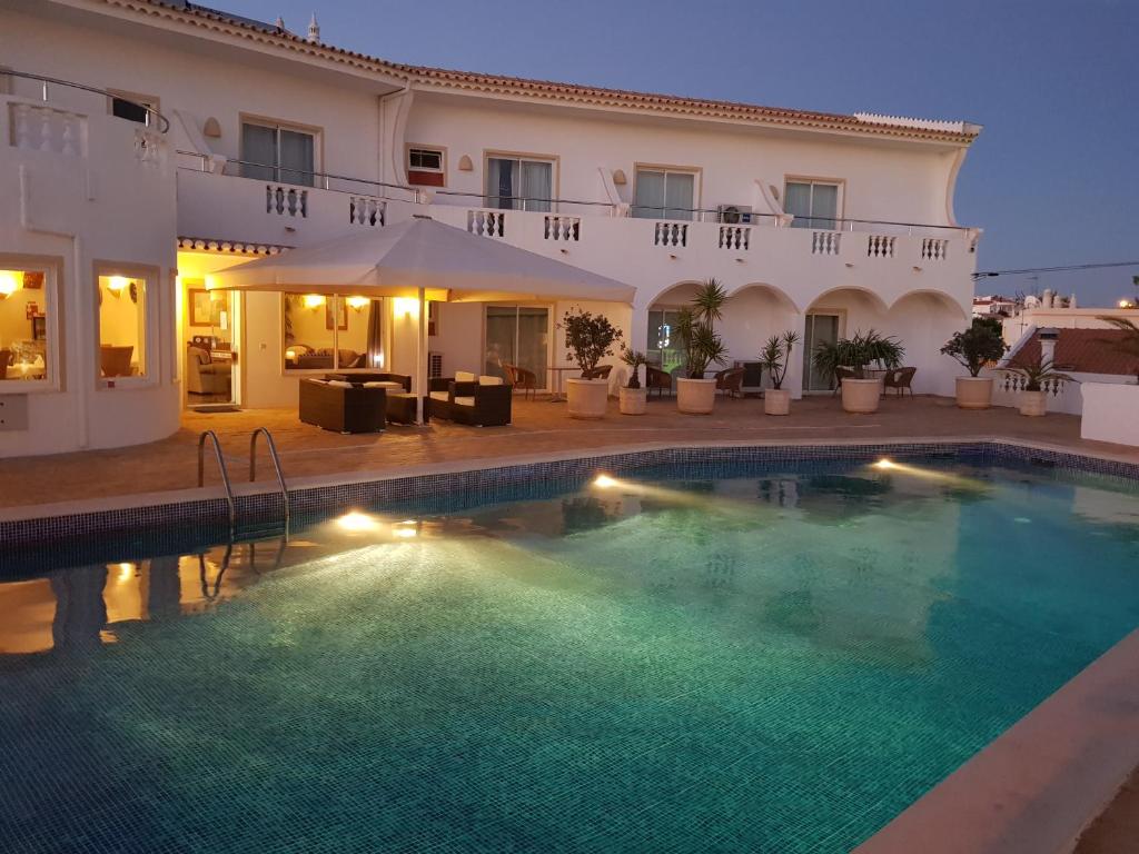 a villa with a swimming pool at night at Vila Channa - Adults Only in Albufeira