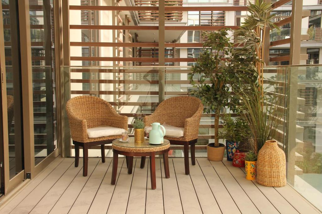 a patio with two chairs and a table on a balcony at Serenity Apartment - City Walk in Dubai