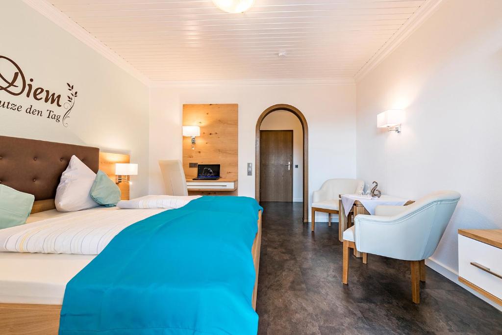une chambre d'hôtel avec un lit, une table et des chaises dans l'établissement Gräfliches Hotel Alte Post, à Bad Birnbach