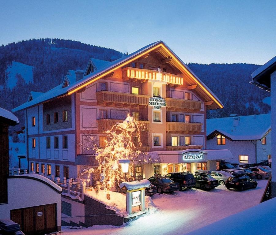 ein großes Gebäude mit einem Weihnachtsbaum davor in der Unterkunft Hotel Garni Serfauserhof in Serfaus