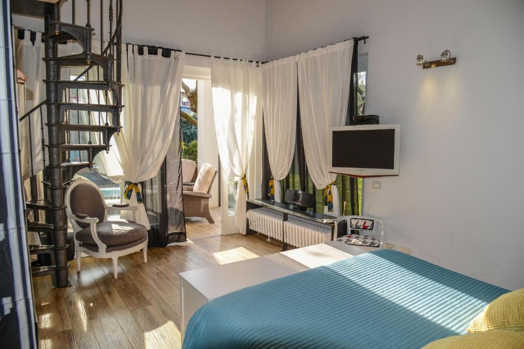 パデンゲ・スル・ガルダにあるCaprapanca Holiday Homeのベッドルーム1室(ベッド1台、テレビ付)、階段