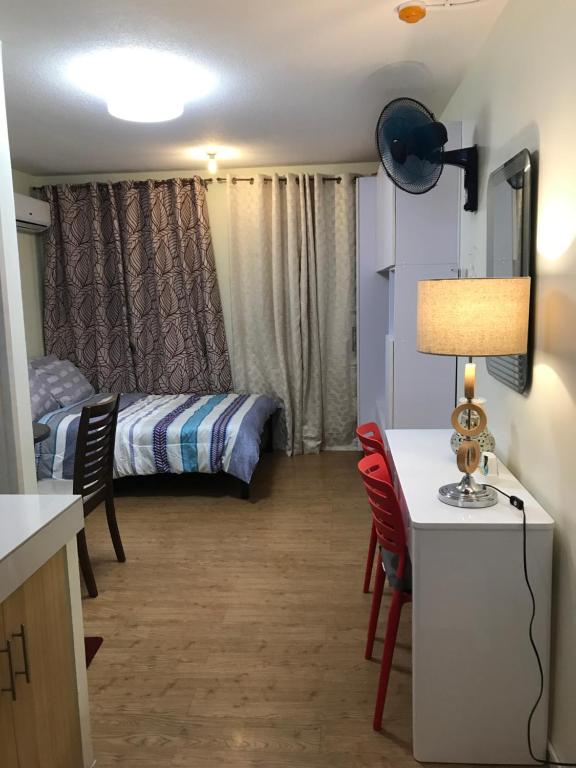 ein kleines Zimmer mit einem Bett, einem Tisch und Stühlen in der Unterkunft San Remo Oasis, Citta De Mari in Cebu City