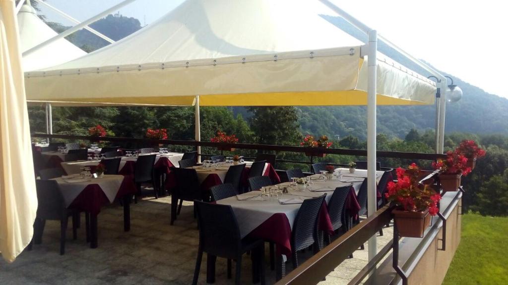 un restaurant avec des tables et des chaises sous un auvent blanc dans l'établissement Hotel Ristorante La Sorgente, à Plesio