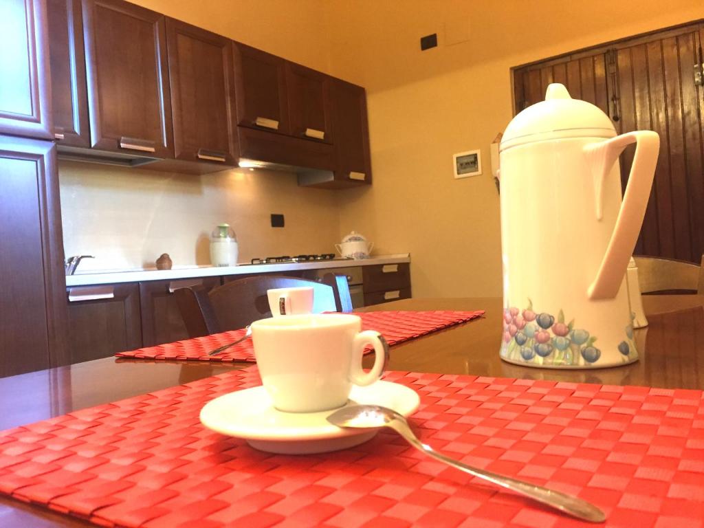 eine Tasse und ein Löffel auf einem Tisch in der Küche in der Unterkunft Palazzo di Città in Saluzzo