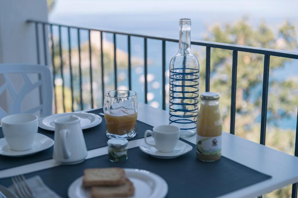 a table with plates of food and a bottle on a balcony at Villa Crawford in San Nicola Arcella
