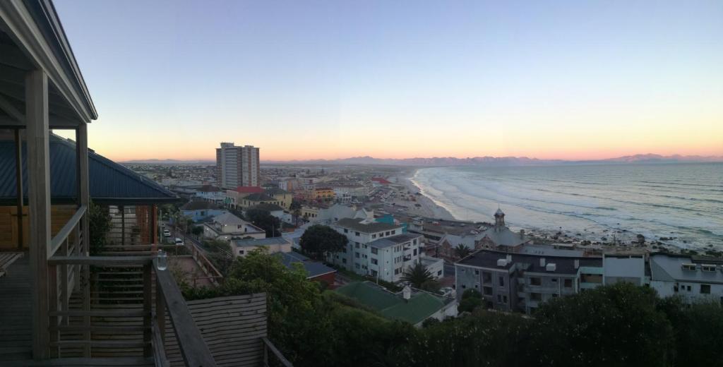 a view of a city and the beach at sunset at Seaview Apartment in Muizenberg in Muizenberg
