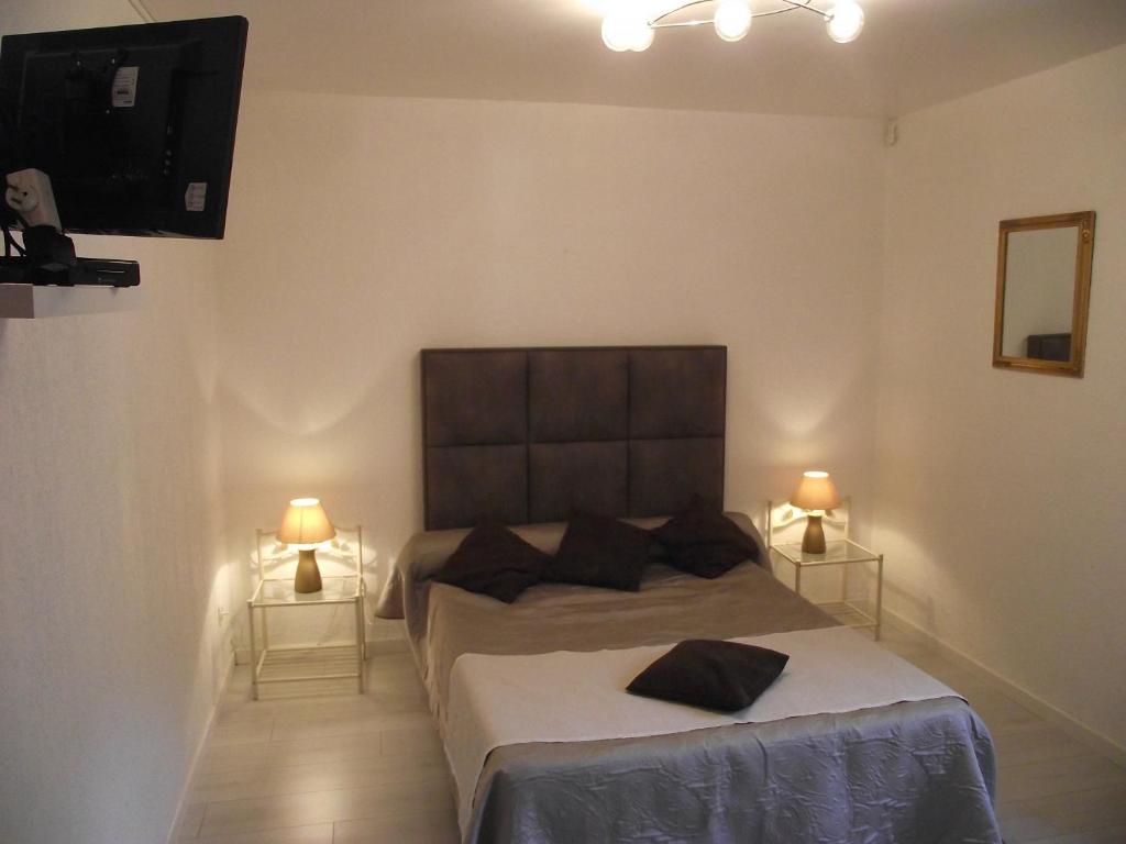 a bedroom with a bed with two night stands and a television at Villa Emmony in Santo-Pietro-di-Venaco